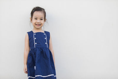 Portrait of girl standing against white background