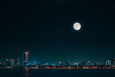 Illuminated cityscape against sky at night