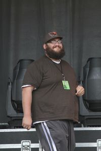 Mid adult man looking away while standing against wall