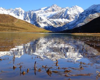 Scenic view of lake and mountains against blue sky