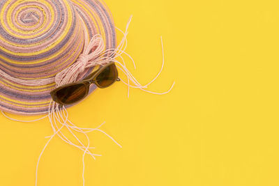 Close-up of multi colored hat against yellow background