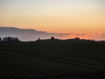 Scenic view of field against sky during sunset