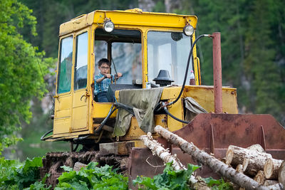 Man and yellow cart on plants