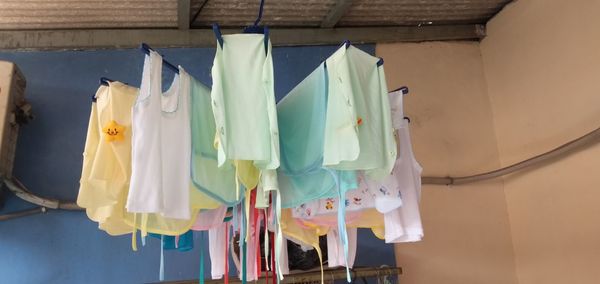 Low angle view of clothes drying on clothesline against wall