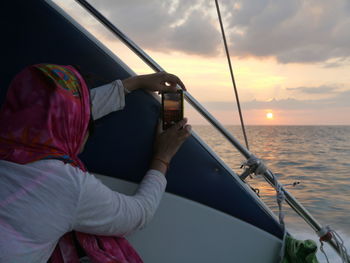 Boat in sea at sunset