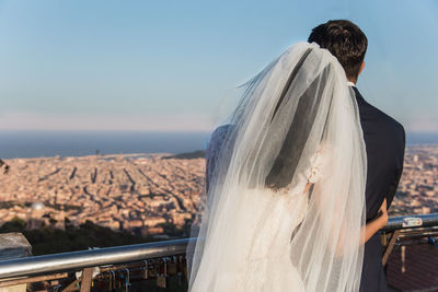 Rear view of couple standing against clear sky