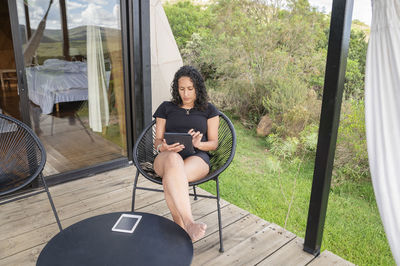 Portrait of young woman sitting on window