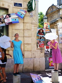 People standing on street against buildings in city