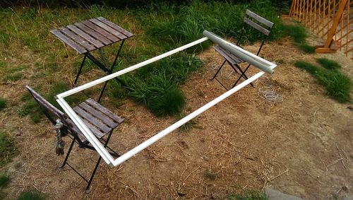 Empty wooden bench on grassy field