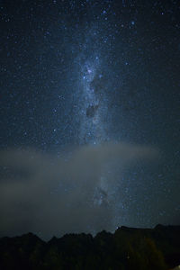 Low angle view of silhouette mountain against sky at night