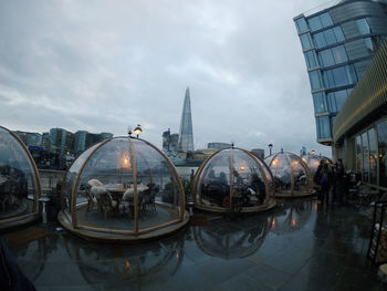 Boats moored in city against sky