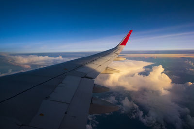 Airplane flying over clouds against blue sky