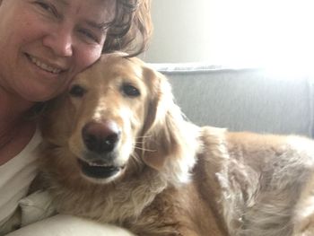 Portrait of man with dog sitting at home