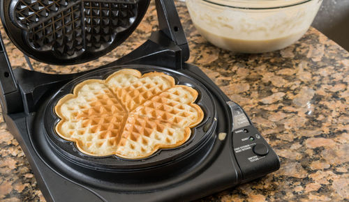 High angle view of fresh waffle on iron in kitchen at home