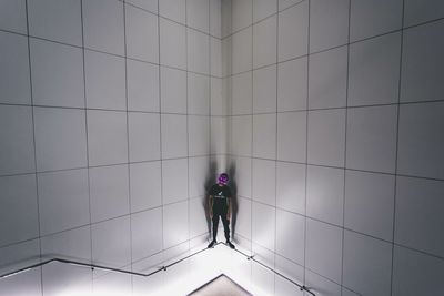 Rear view of man and woman walking on tiled floor