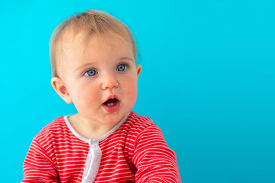 Close-up of cute baby boy against blue background