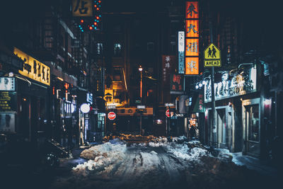 Illuminated city street at night during winter