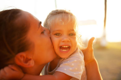 Close-up of mother kissing on daughter cheek