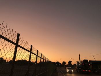 Cars on road against sky during sunset