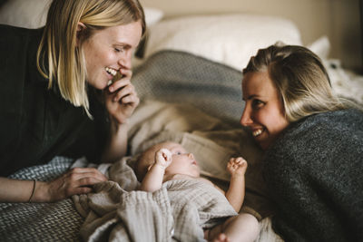 Mothers lying in bed with newborn baby