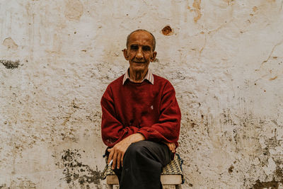 Portrait of man standing against wall