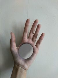 Digital composite image of hole in hand against wall