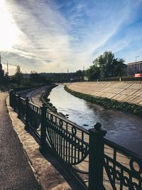 Bridge over river in city against sky