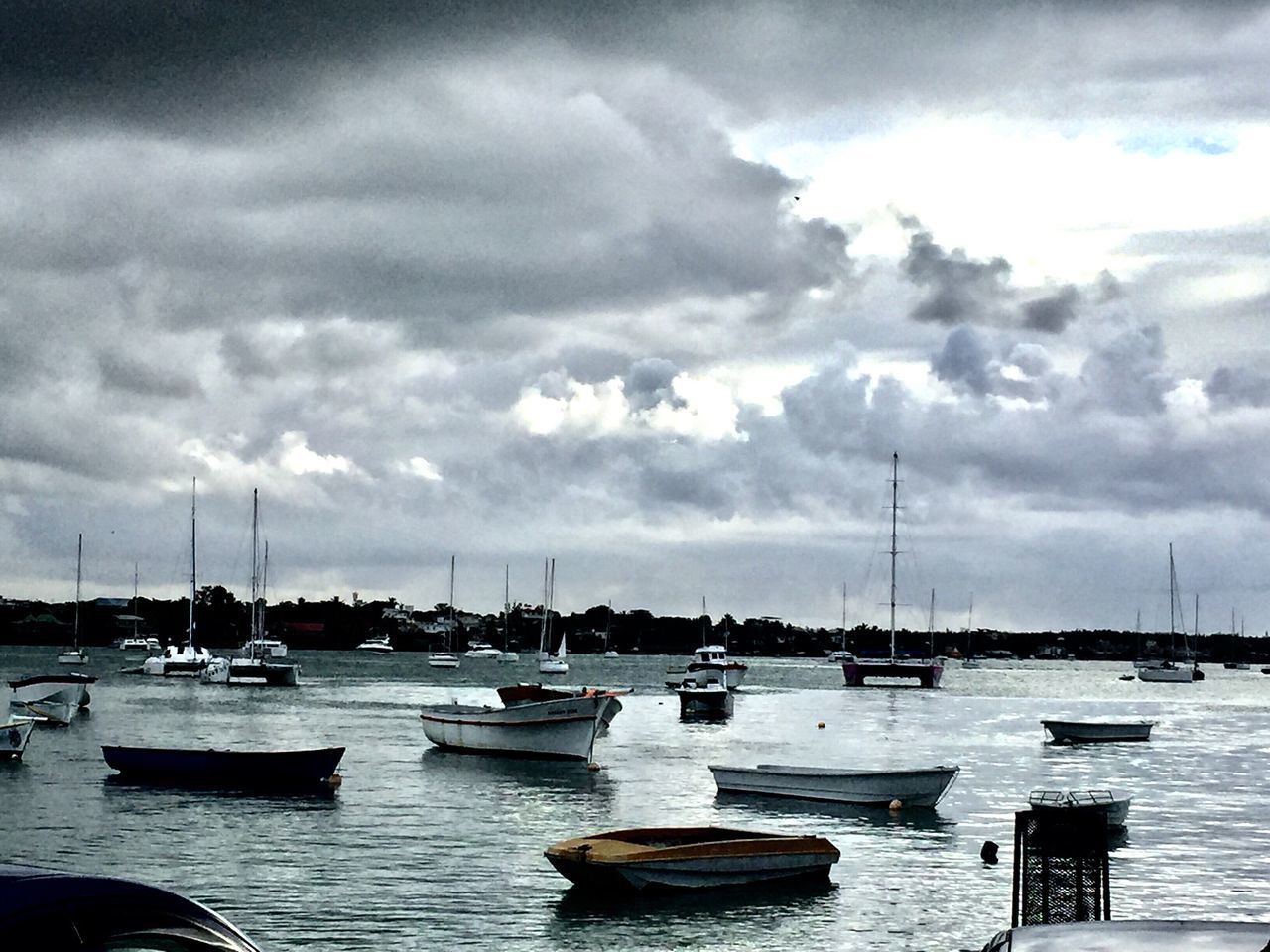 BOATS MOORED IN HARBOR AGAINST SKY