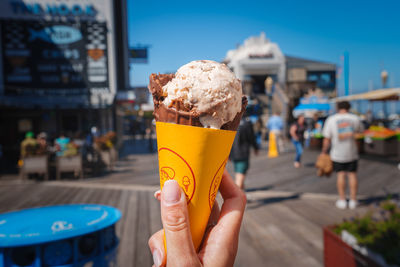 Cropped hand holding ice cream cone