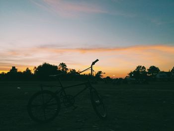 Bicycle against sky during sunset