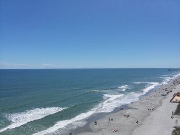 Scenic view of beach against clear blue sky