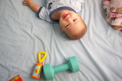 High angle view of cute boy lying on bed at home