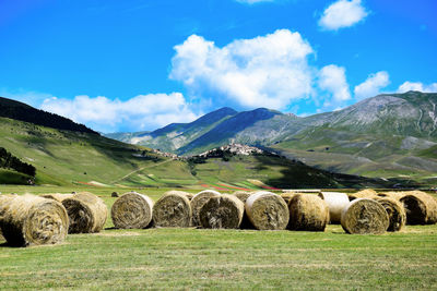 Hay bales on field against sky