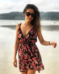 Portrait of beautiful young woman wearing sundress at beach