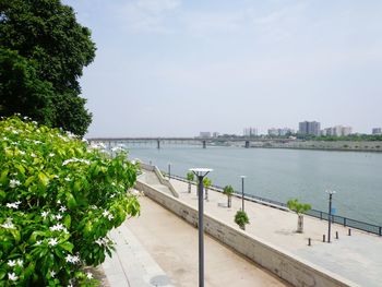 Scenic view of river by city against sky