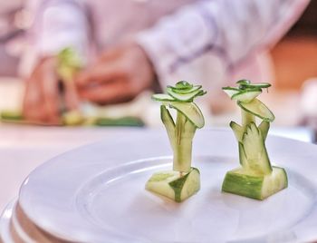 Close-up of blurredbchef slicing apples on a plate on table