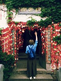 Rear view of woman standing at entrance of temple