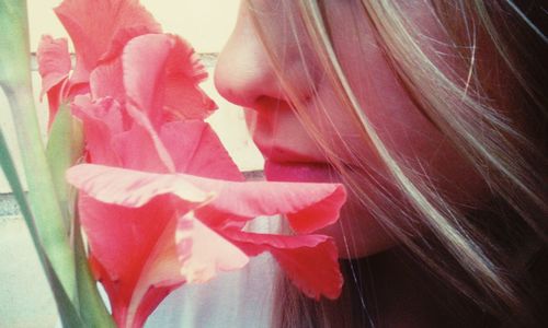 Close-up portrait of woman with pink rose