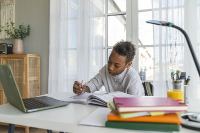 Boy studying on table at home