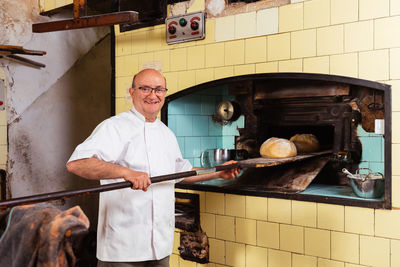 Midsection of man preparing food in factory