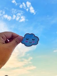 Person holding umbrella against blue sky