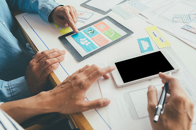 Midsection of man using mobile phone on table