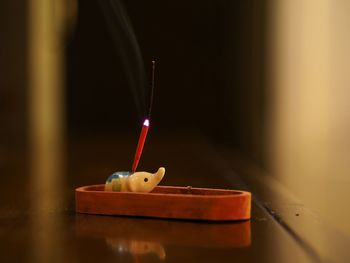 Close-up of lit candle on table