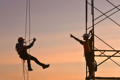 Low angle view of silhouette man standing against clear sky during sunset