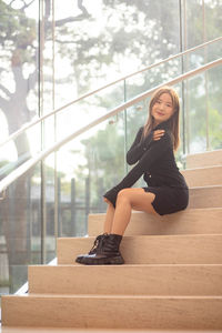 Portrait of young woman sitting on steps
