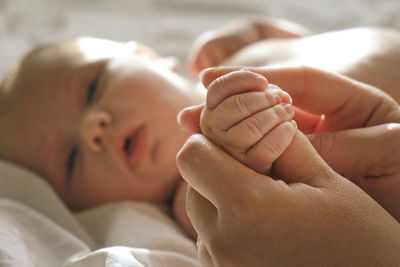 Mother giving massage to little child infant.  female hands massaging to newborn.  cream, body care