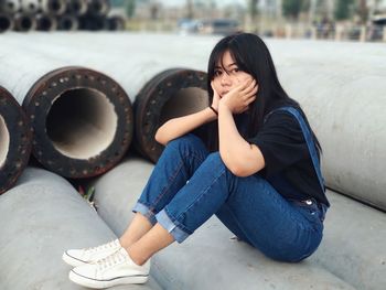 Full length of a young woman sitting outdoors