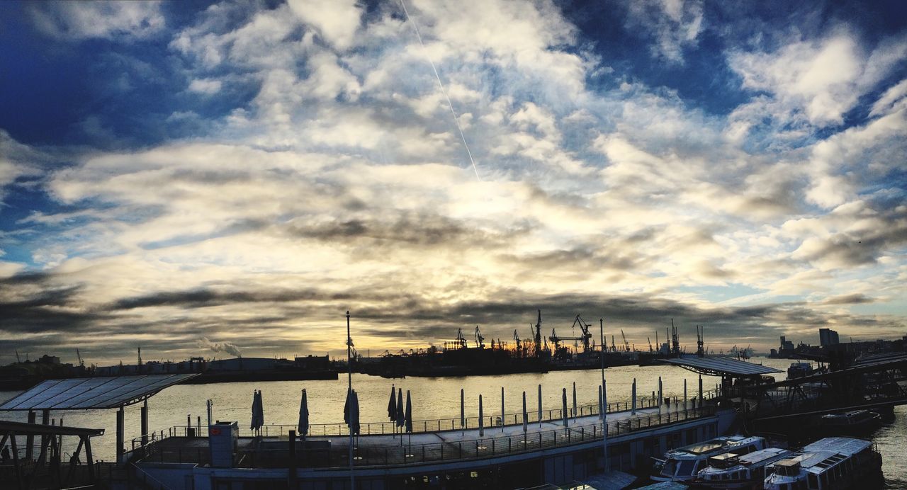 sky, cloud - sky, cloudy, built structure, transportation, harbor, nautical vessel, architecture, mode of transport, water, building exterior, weather, commercial dock, cloud, crane - construction machinery, dusk, moored, sea, silhouette, city