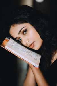 Portrait of young woman holding book