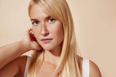 Portrait of young woman against pink background